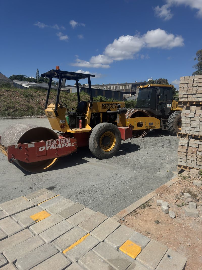 Rolo compactador ao lado de área com piso intertravado
